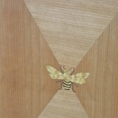 Detail:  Quarter cut cherry door with diamond pattern and inlaid bee, anigre and